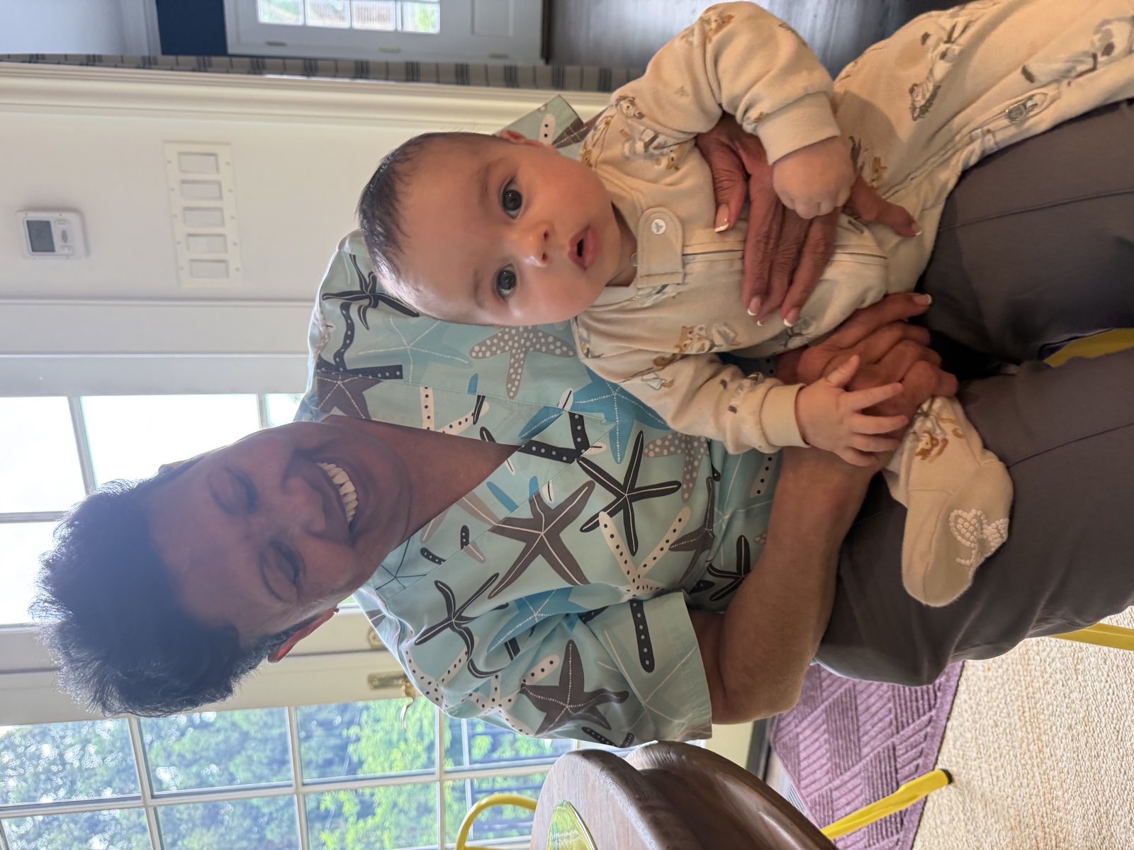 Jennifer smiling while holding a baby on her lap